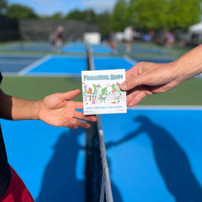 Handing a Pickleball Slam game box to another player on a court